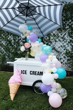 an ice cream cart is decorated with balloons