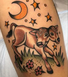 a tattoo with an image of a baby cow on it's leg and the moon in the background