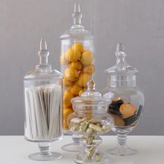 three glass jars filled with different types of candies