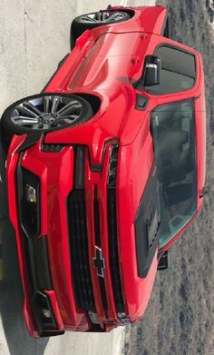 an overhead view of a red sports car parked on the side of a road with its roof down