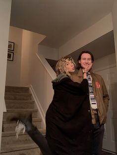 a man and woman standing in front of some stairs