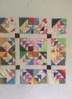 a colorful quilt hanging on the wall