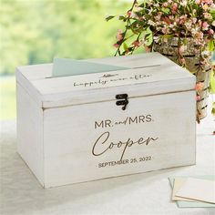 a white wooden box with the words mr and mrs written on it next to flowers