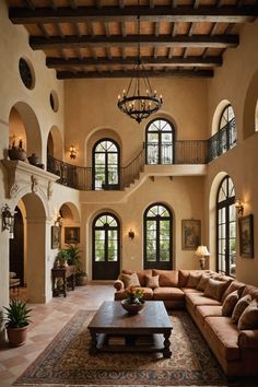 a living room filled with lots of furniture next to a tall ceiling mounted chandelier