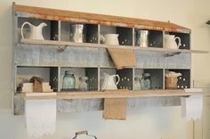 an old wooden shelf filled with lots of jars and other items on top of it