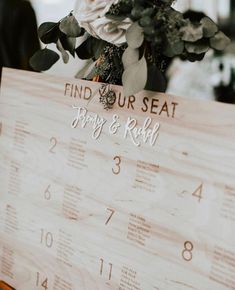 a wooden sign that says find your seat, marry and ride with flowers in it