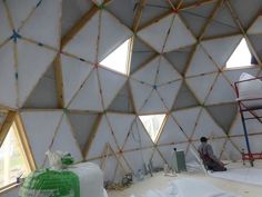 a man sitting on a chair in front of a large white dome with wood trimmings