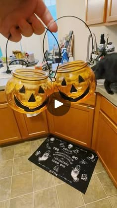 two pumpkin shaped glasses sitting on top of a kitchen counter next to a black cat