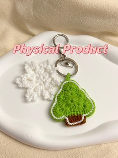 a crocheted keychain with a green tree and snowflake on it