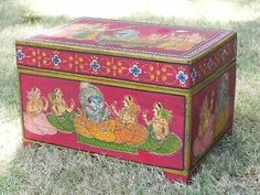 an ornate painted box sitting in the grass