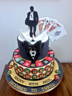 a casino themed birthday cake with playing cards and a card holder on top that says happy fortyth paul