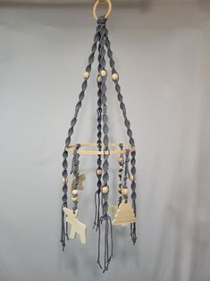 a wind chime hanging from the ceiling with beads and wooden animals attached to it