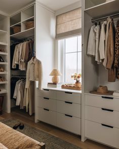 an organized closet with clothes and shoes on the shelves, along with a bed in the foreground