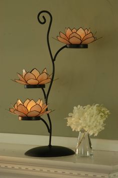 a lamp that is sitting on top of a table next to a vase with flowers in it