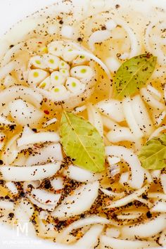 a white bowl filled with noodles and herbs