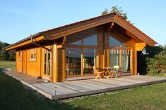 a small wooden cabin sitting on top of a lush green field