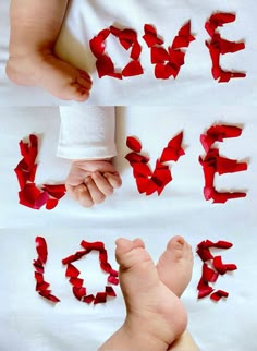 two hands holding the word love made out of red tissue paper on top of a white sheet