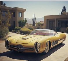 an old fashioned yellow car parked in front of a house with cactus trees behind it