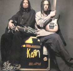 two men sitting next to each other with guitars in front of them and the words korn on their chest