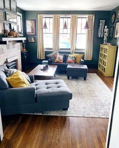 a living room filled with furniture and a fire place in the middle of a wooden floor