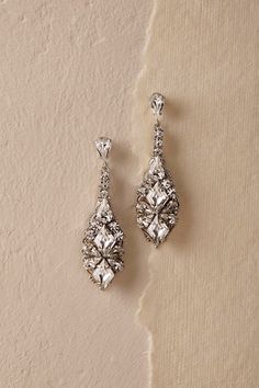 two pairs of earrings on a beige background