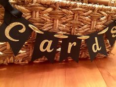 a basket that has some black and gold letters on it with the words cards spelled out