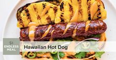 a grilled hot dog on a plate with pineapples