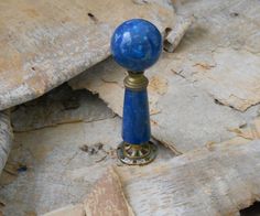 a blue knob sitting on top of a piece of wood