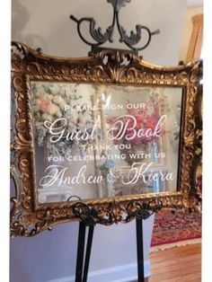 an ornate gold frame holds a wedding sign