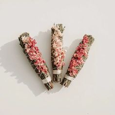 three bundles of dried flowers sitting next to each other