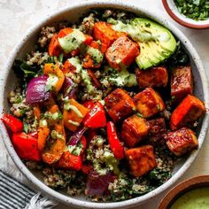 a bowl filled with rice, vegetables and tofu