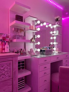 a pink vanity with lighted lights in a room