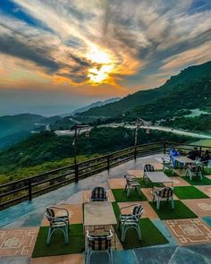 an outdoor dining area with tables and chairs overlooking the mountains