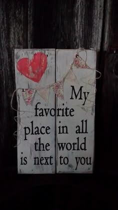 two wooden signs that say, my favorite place in all the world is next to you