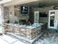 an outdoor kitchen with stone counter tops and grilling area