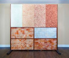 a room with different colored tiles on the wall and wood flooring in front of it