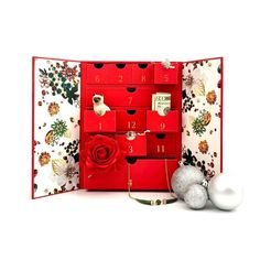 a red box with christmas decorations and ornaments in front of it on a white background