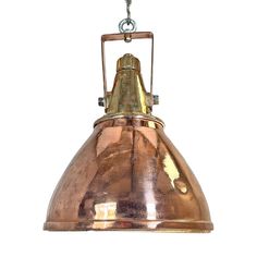 a large copper colored light hanging from a chain