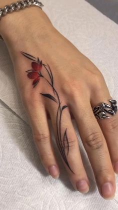 a woman's hand with a flower tattoo on it