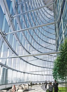 people are walking around in front of a glass and steel building that has many windows