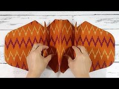 someone is making an origami butterfly out of paper with their hands and fingers