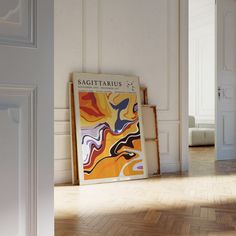 a poster on the floor in an empty room with white walls and parquet floors