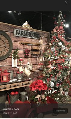 a christmas tree in front of a wooden wall with farm house signs on the side