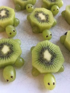 sliced kiwis and grapes on a white surface