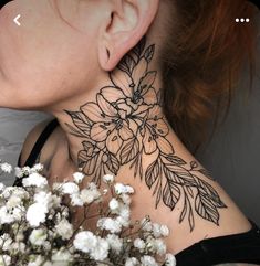 a close up of a woman's neck with flowers and leaves on her neck