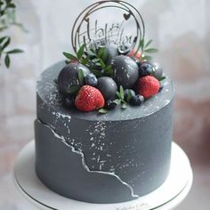 the cake is decorated with berries and leaves