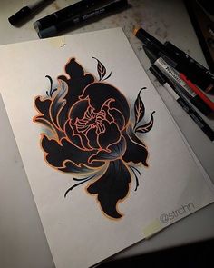 a drawing of a flower on paper next to markers