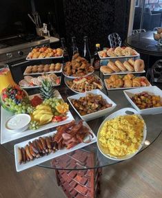 a glass table topped with lots of different types of foods and pastries on it