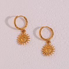 Brighten your day with our radiant with the Sun Goddess Earrings, beautifully crafted in 18k gold. These earrings feature a stunning sun charm that captures the essence of celestial beauty and modern sophistication. Tarnish-free and lightweight, they are perfect for adding a touch of shine to any outfit. Material: 316L Stainless Steel, 18k gold finish Weight: 3g/pair Unique sun charm design Tarnish-free and lightweight Waterproof, Hypoallergenic Celestial Style Gold-plated Yellow Gold Hoop Earrings, Celestial Style Yellow Gold Plated Hoop Earrings, Celestial Yellow Gold Tarnish-resistant Hoop Earrings, Celestial Yellow Gold Plated Earrings, Celestial Style Tarnish Resistant Earrings, Celestial Style Yellow Gold Plated Earrings, Celestial Yellow Gold-plated Earrings, Elegant Sun Design Earrings As Gift, Celestial Drop Earrings Tarnish Resistant