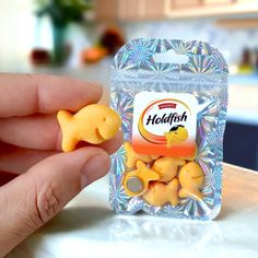 a hand holding a packaged package of yellow dog shaped candies